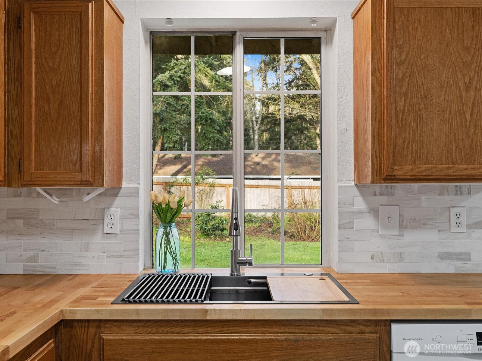 7822 Songbird Way Clinton, WA 98236 - Photo 11 of 28 a view of a kitchen with a sink and dishwasher kitchen view with wooden floor