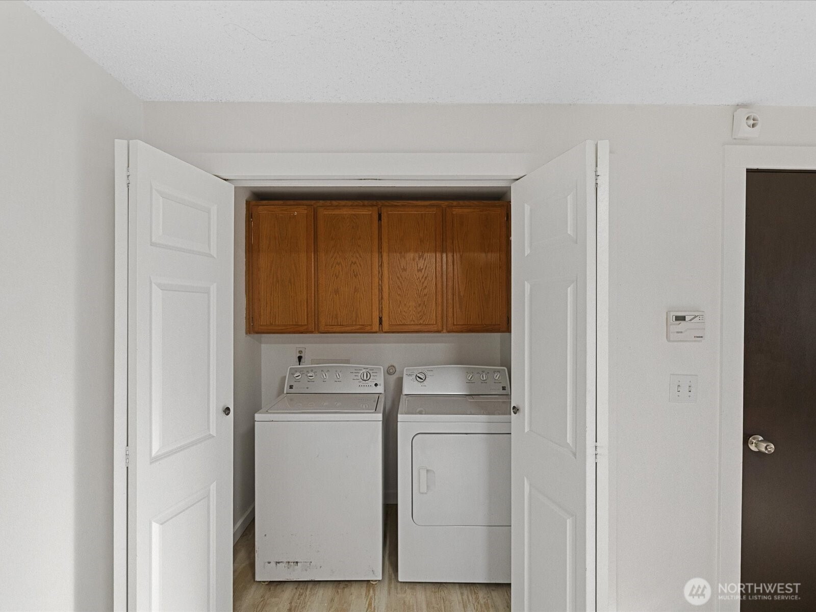 7822 Songbird Way Clinton, WA 98236 - Photo 14 of 28 a utility room with cabinets washer and dryer