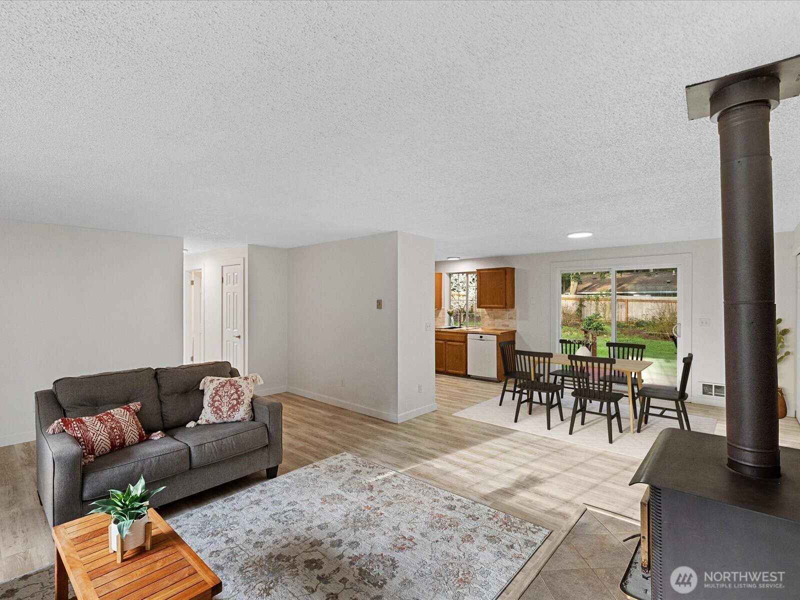 7822 Songbird Way Clinton, WA 98236 - Photo 16 of 28 a living room with furniture and a dining table with wooden floor