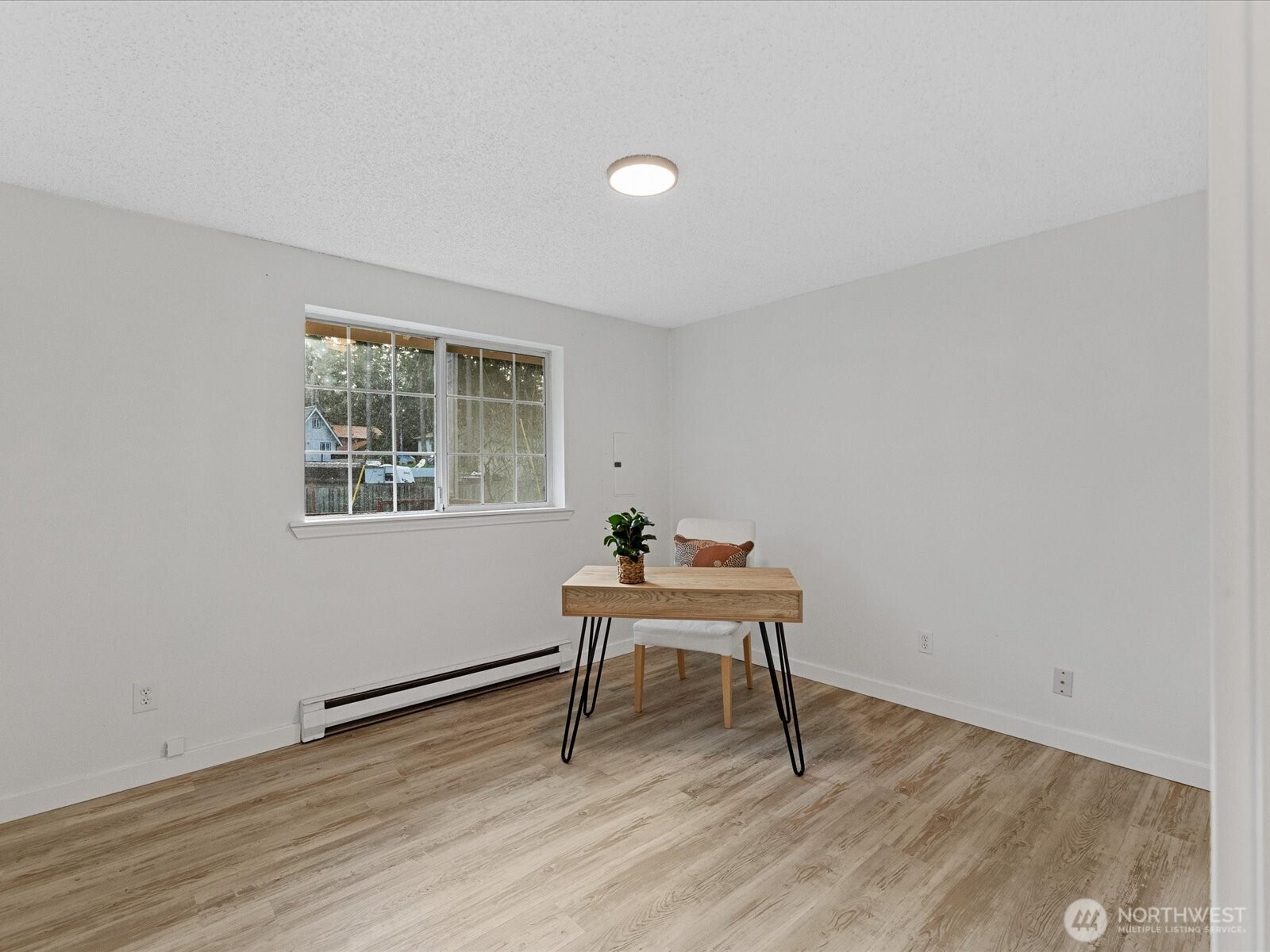 7822 Songbird Way Clinton, WA 98236 - Photo 19 of 28 a view of a workspace with wooden floor and a window