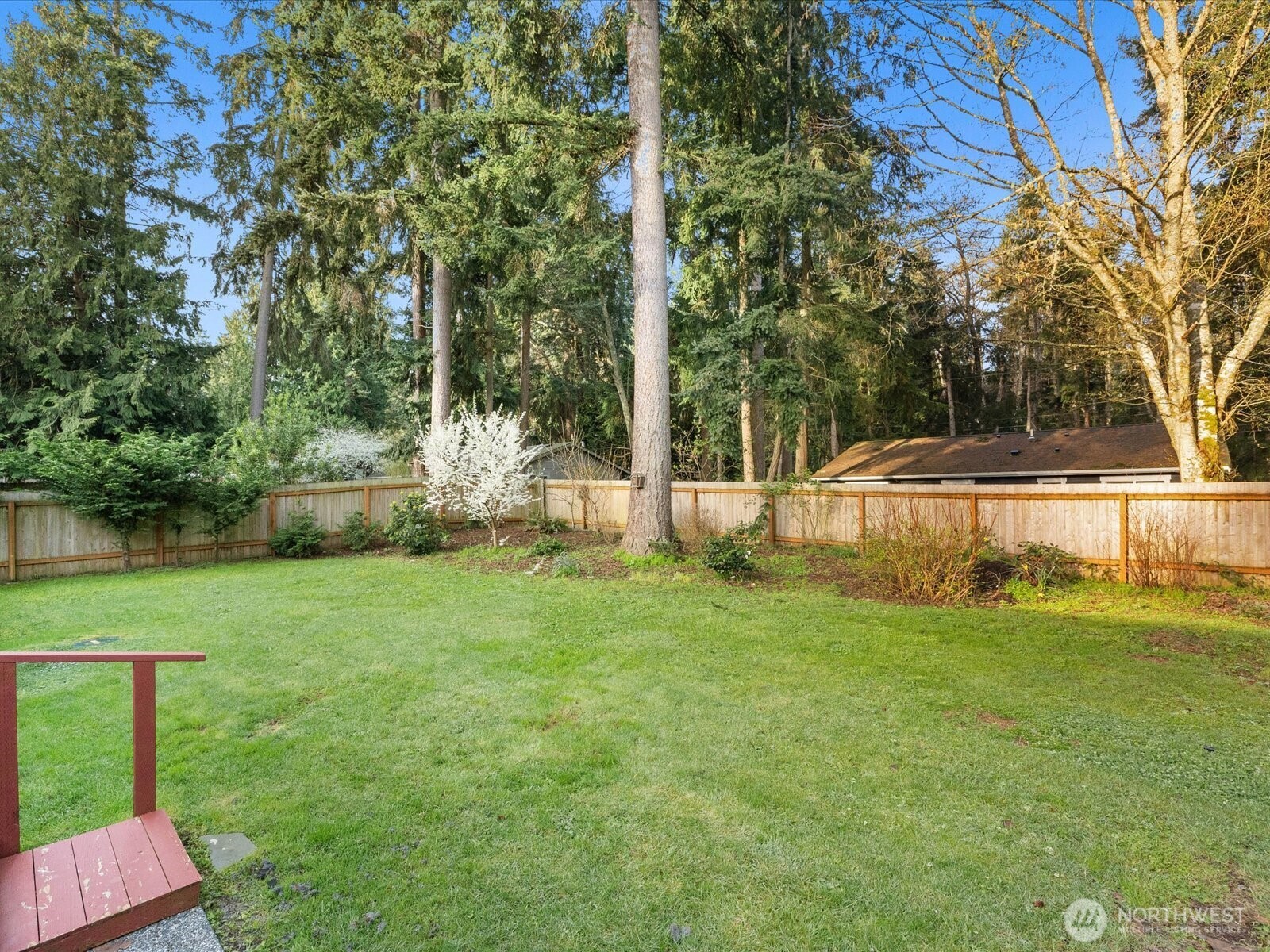 7822 Songbird Way Clinton, WA 98236 - Photo 25 of 28 a backyard of a house with lots of green space and fountain