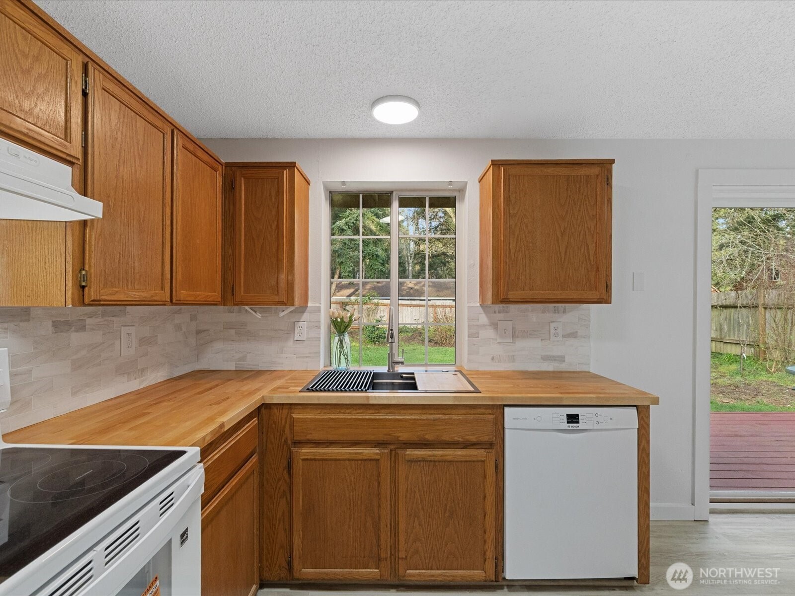 7822 Songbird Way Clinton, WA 98236 - Photo 10 of 28 a kitchen that has a sink and a stove in it