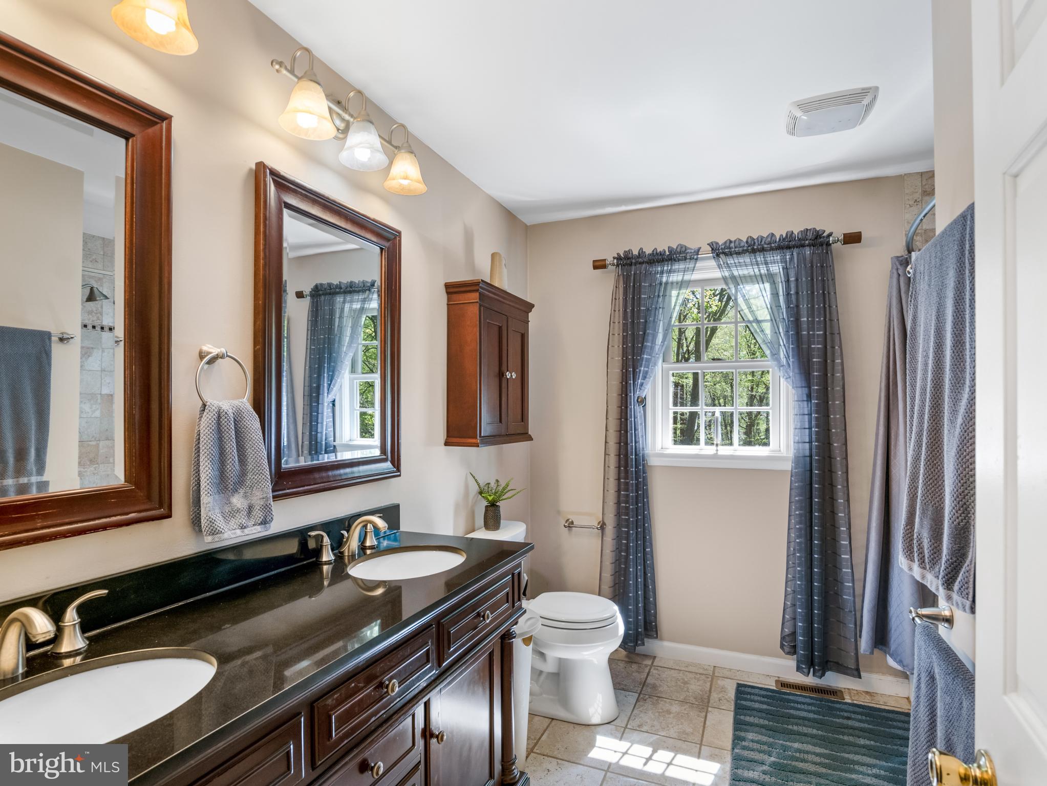5 Radburn Lane Landenberg, PA 19350 - Photo 40 of 67 a bathroom with a granite countertop sink a toilet a mirror and a window