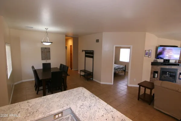 a living room with furniture a flat screen tv and kitchen view