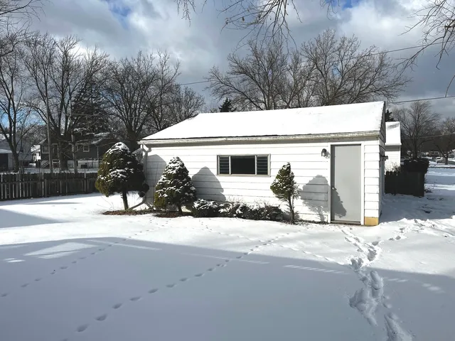 a view of a house with a yard covered in snow
