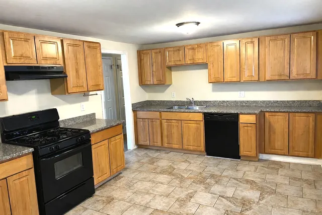 a kitchen with a stove sink and cabinets