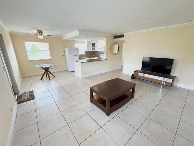a living room with furniture a flat screen tv and a table