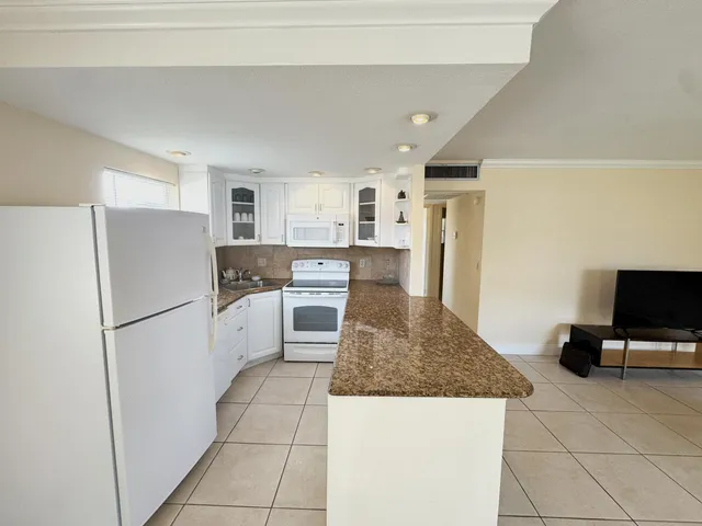 a kitchen with a refrigerator a stove top oven and a counter top space