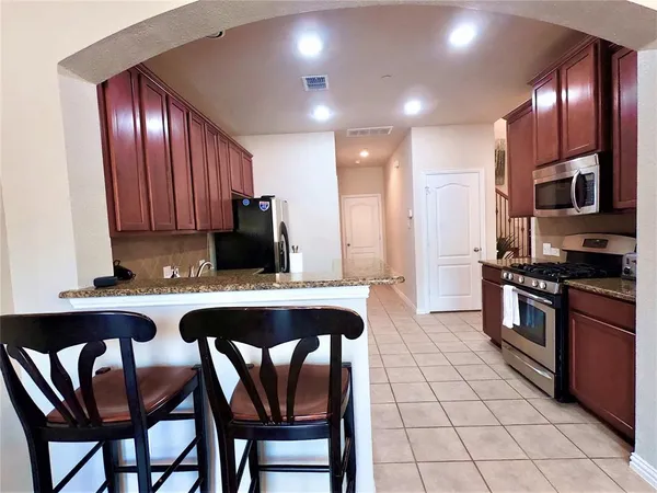 a kitchen with stainless steel appliances granite countertop a stove a sink and a refrigerator
