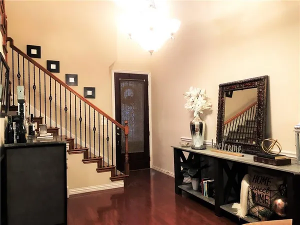 a view of a hallway with wooden floor and staircase