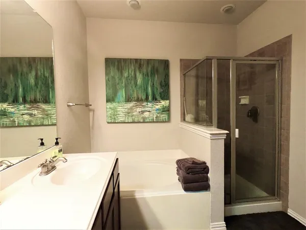 a bathroom with a tub a sink and a large mirror