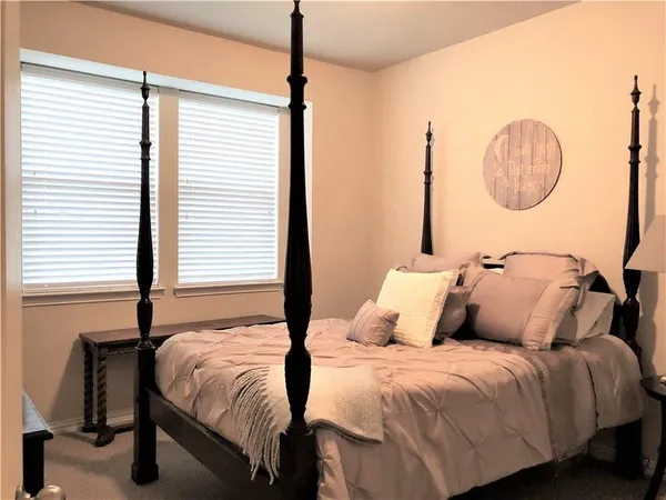 a bedroom with a large bed and a window