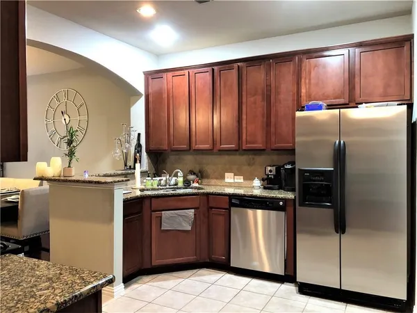 a kitchen with stainless steel appliances granite countertop a stove a refrigerator and a sink