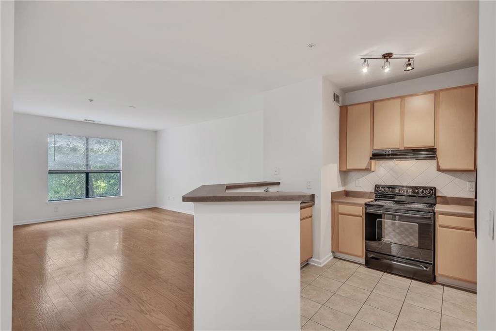 a kitchen with stainless steel appliances granite countertop a stove a sink and a microwave