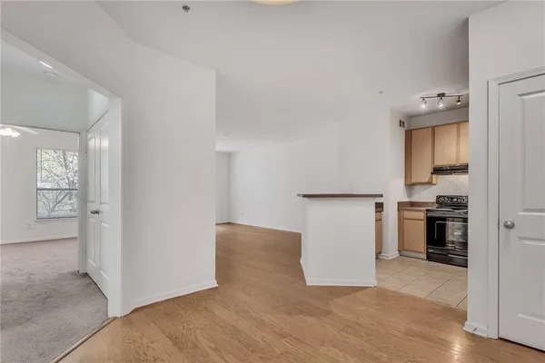 a view of a kitchen with refrigerator and wooden floor