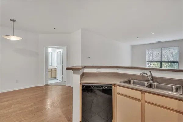 a kitchen with a sink cabinets and a wooden floor