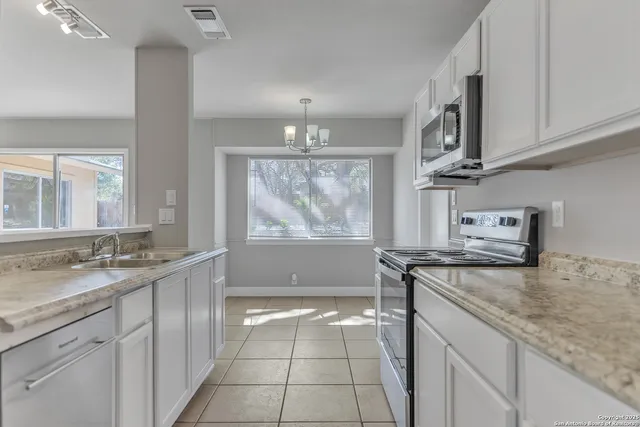 a kitchen with stainless steel appliances granite countertop a sink stove and cabinets