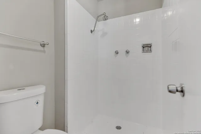 a bathroom with a shower a toilet and a shower