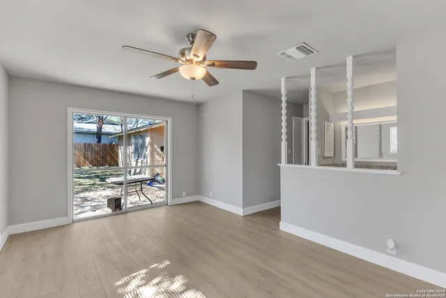 a view of a livingroom with wooden floor and a ceiling fan