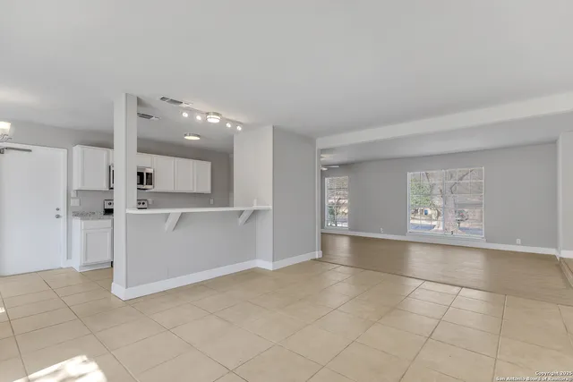 a view of a kitchen with white cabinets and a sink