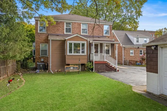 a view of a house with a yard and sitting area