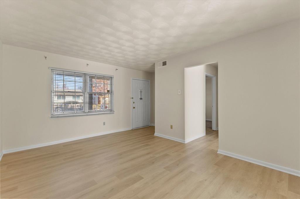 4110 Colgate Lane Garland, TX 75042 - Photo 9 of 22 an empty room with wooden floor and windows
