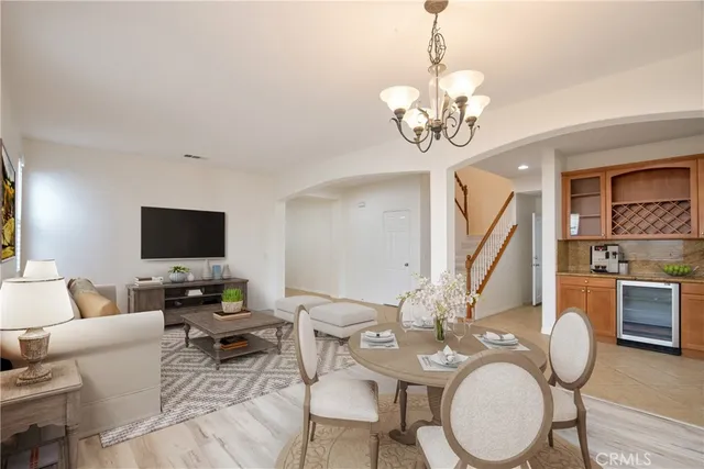 a living room with couches a dining table and a stove with wooden floor