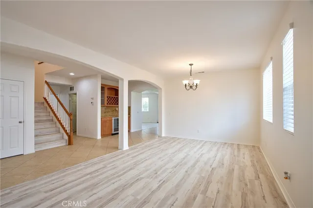 a view of a livingroom with a fireplace a chandelier and wooden floor