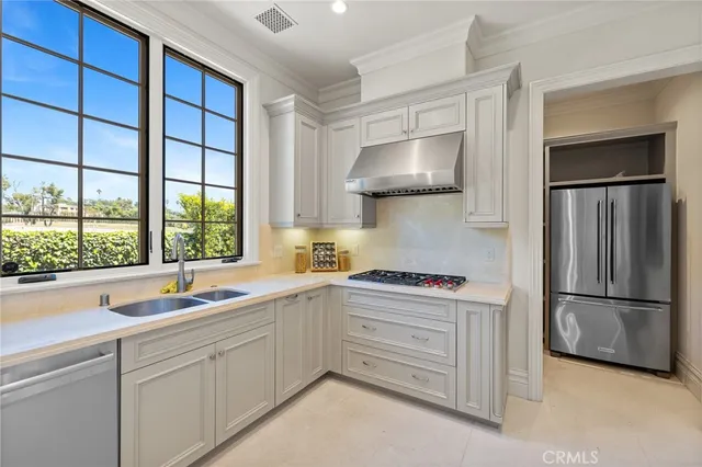 a spacious bedroom with a bed chandelier and a window