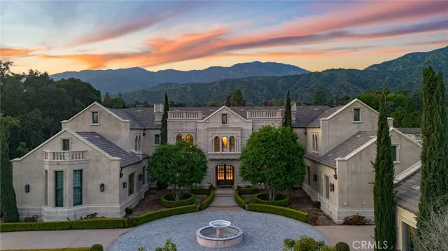a front view of a building with yard and swimming pool