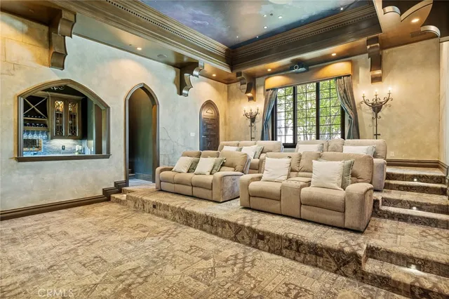 a spacious bedroom with a bed a couch and a chandelier