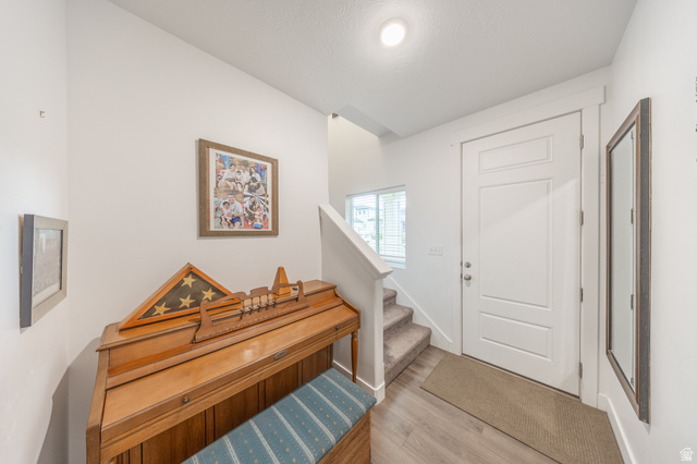 4765 Breezy Patch Road Eagle Mountain, UT 84005 - Photo 6 of 25 Entryway featuring a white paneled door, light wood-finish flooring, and a window with blinds
