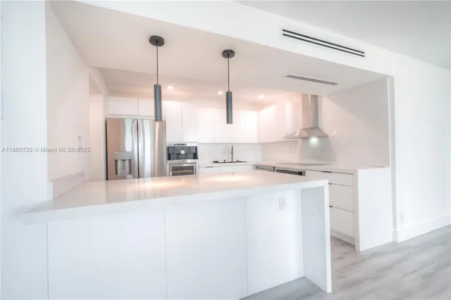 a kitchen with kitchen island a stove a sink and a refrigerator