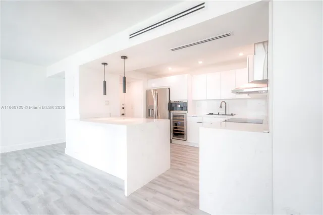 a kitchen with kitchen island a sink a stove and a refrigerator