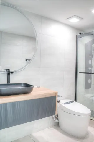 a bathroom with a sink a toilet and shower