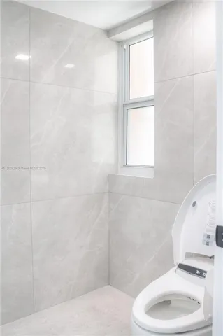 a bathroom with a toilet a sink and a window