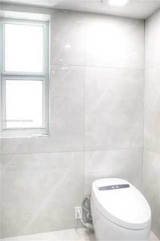 a white toilet sitting next to a window