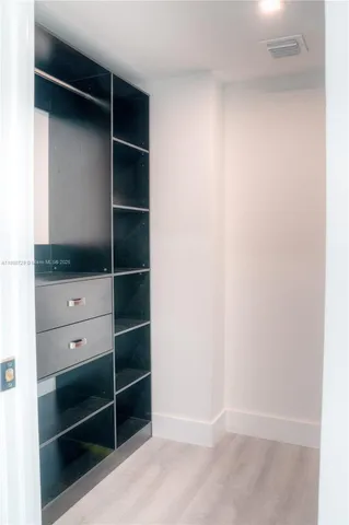 a view of walk in closet with empty racks