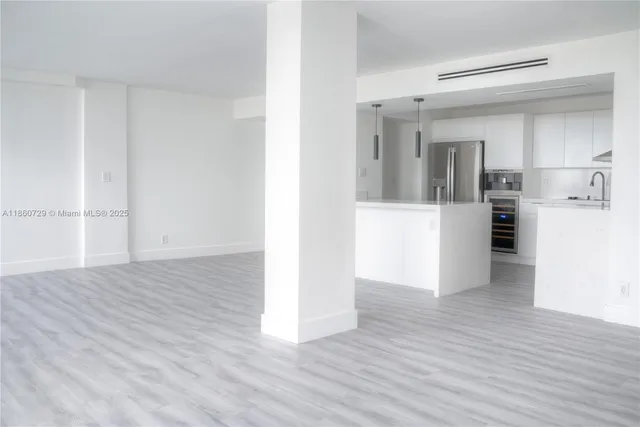 a view of a kitchen with wooden floor and a refrigerator