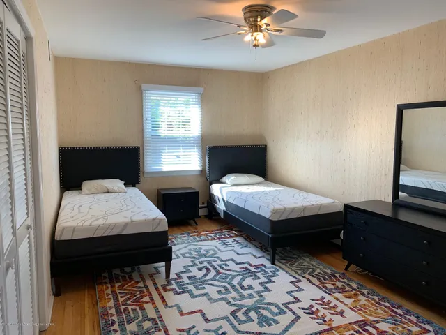 a bedroom with a bed and a lamp on dresser