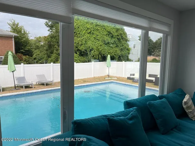 a living room with a floor to ceiling window next to a yard