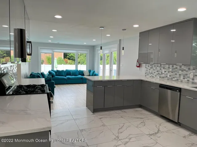 a kitchen with stainless steel appliances granite countertop a refrigerator and a sink
