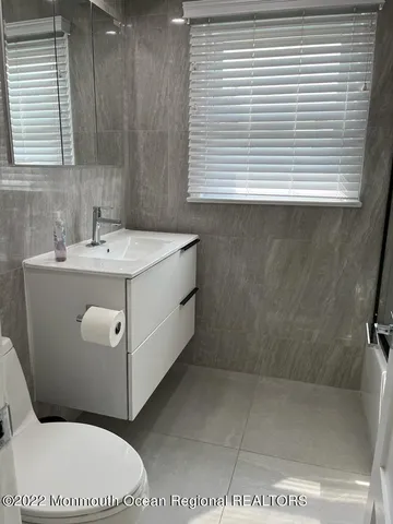 a bathroom with a sink a toilet and window