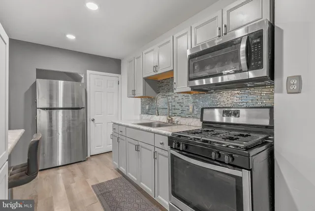 a kitchen with stainless steel appliances granite countertop a stove a refrigerator and a microwave