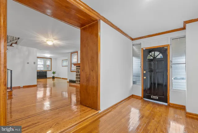 a view of a livingroom with wooden floor and a kitchen space