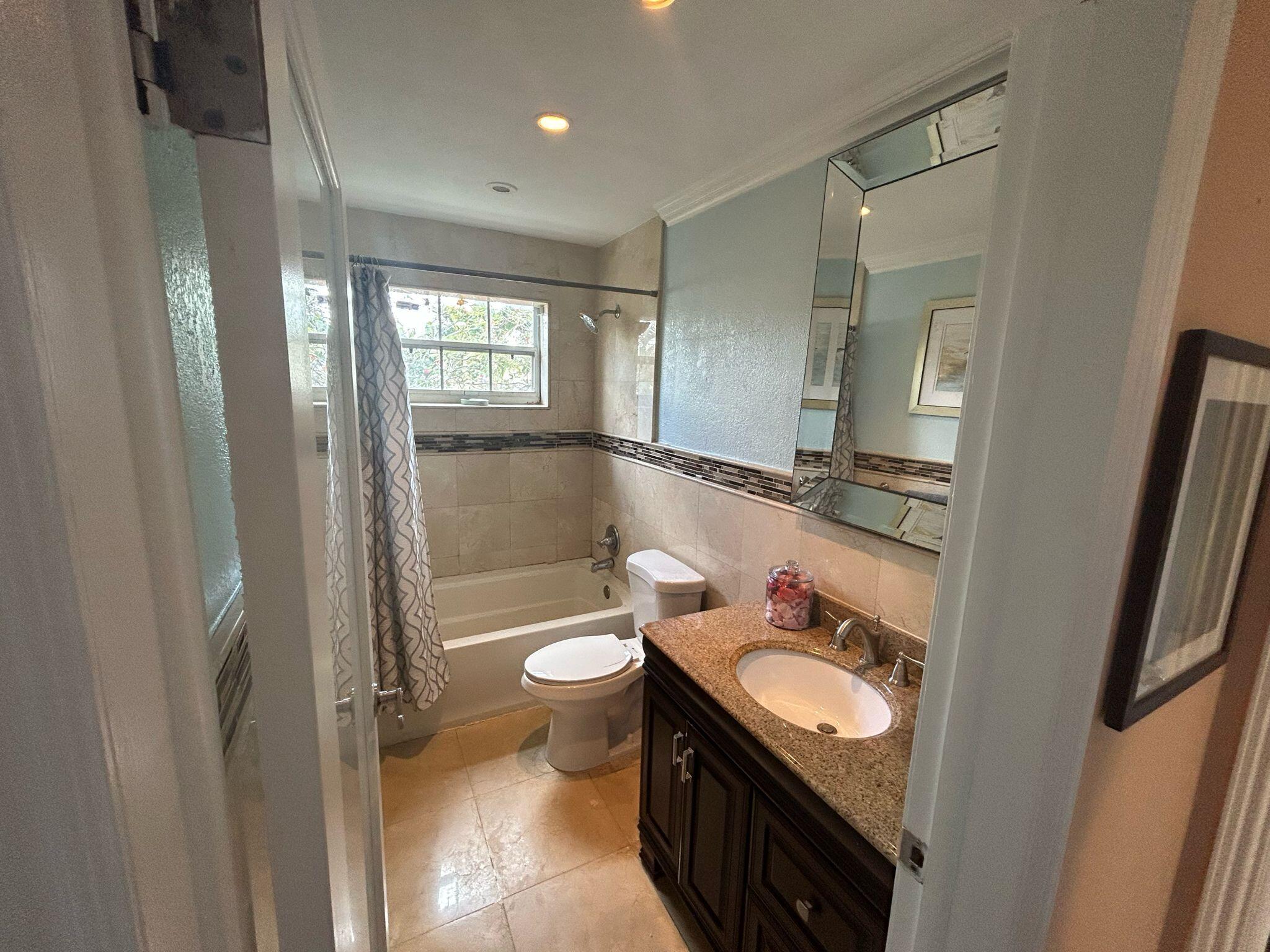 5200 Adams Street Hollywood, FL 33021 - Photo 12 of 24 a bathroom with a granite countertop sink toilet and shower
