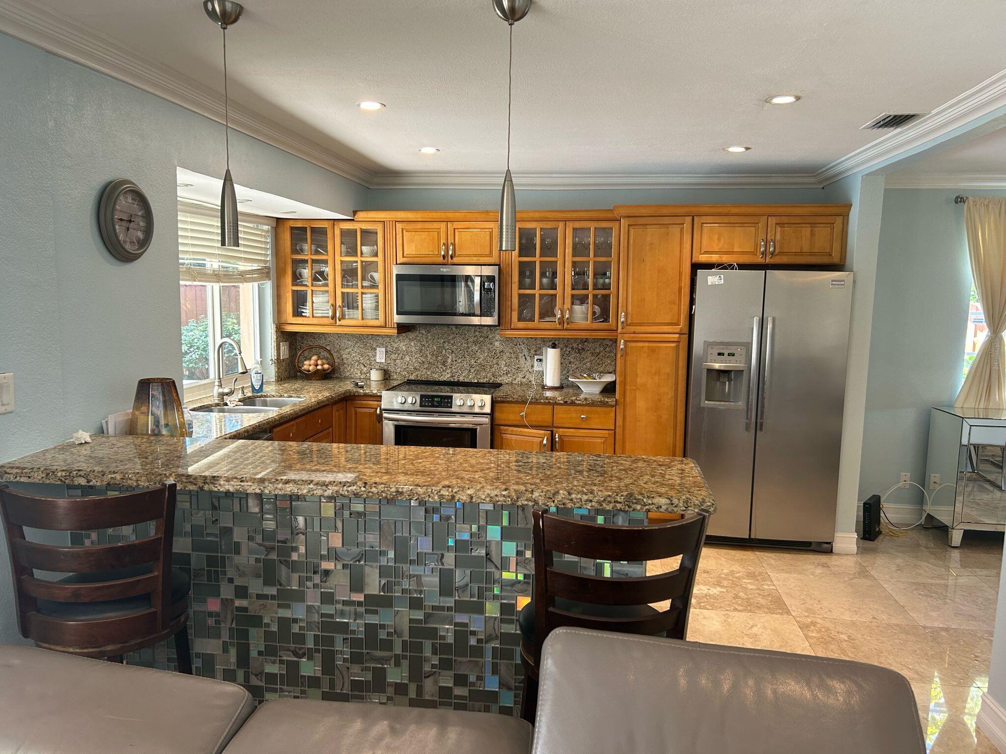 5200 Adams Street Hollywood, FL 33021 - Photo 23 of 24 a kitchen with stainless steel appliances granite countertop a sink a stove and a refrigerator