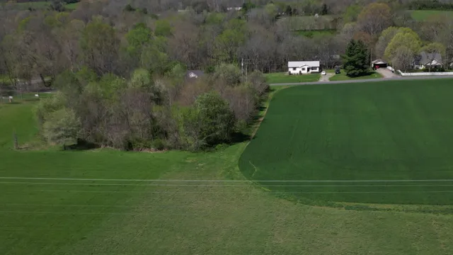 a view of a field with a house in background