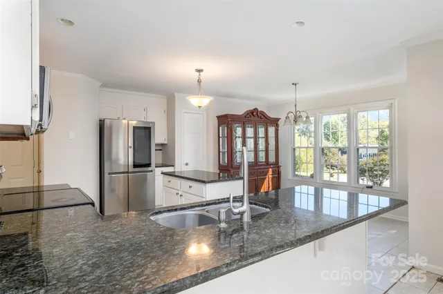 a kitchen with stainless steel appliances granite countertop a refrigerator and a sink