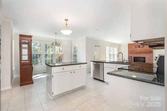 a kitchen with granite countertop white cabinets and appliances